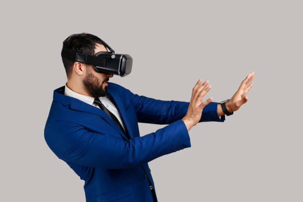 istock Man in vr glasses, stretching hands, trying to grab something while playing virtual reality game. 1394111775