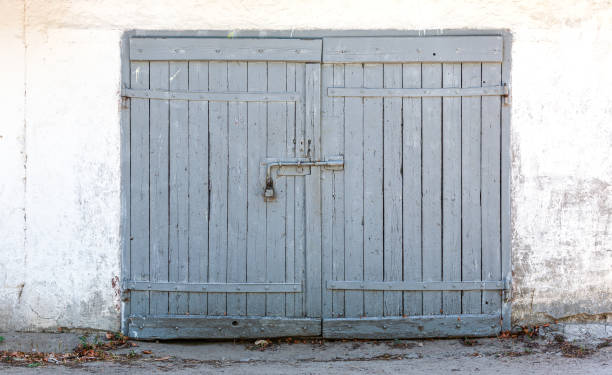 istock old wooden closed gate on white painted weathered plaster wall 1394112815