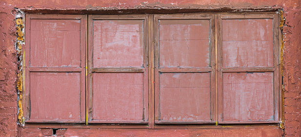 Old window with blue shutters at an abandoned inn.