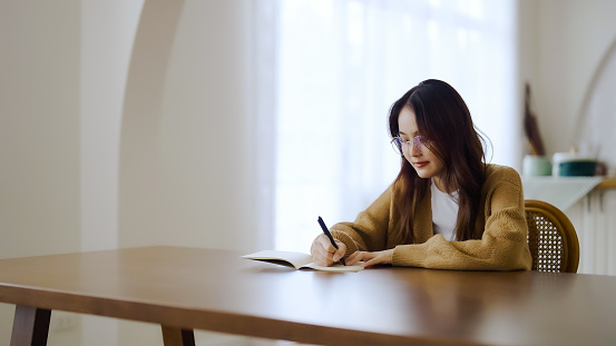 Beautiful young asian woman sitting and taking note at house. Happy smiling working online, Freelance work at home