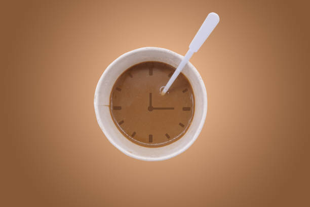 Cup of coffee with clock on brown background