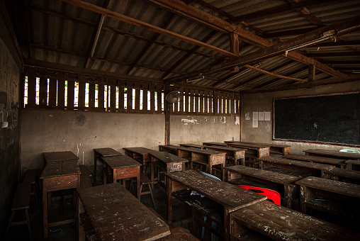Desks and chairs arranged in classroom at  old school.