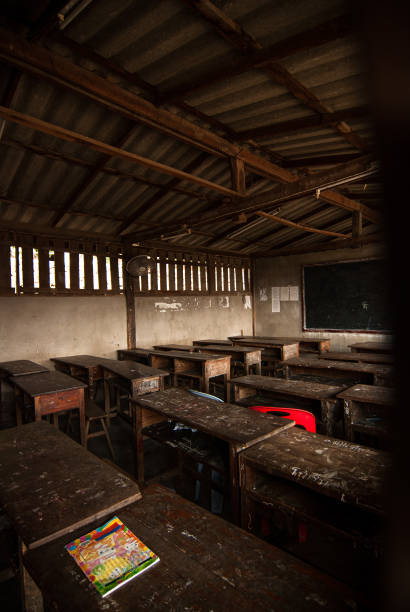 istock Desks and chairs arranged in classroom at  old school. 1394117936
