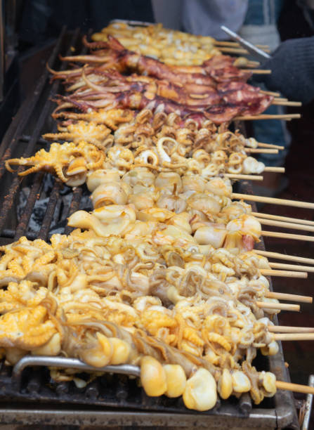 istock Grilled squid on skewers grilled over charcoal ready served. 1394119333