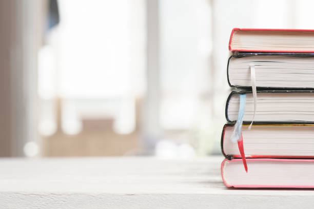 istock Stack of books on wood table. Education learning concept, library and reading. looking up information in encyclopedia. 1394122203