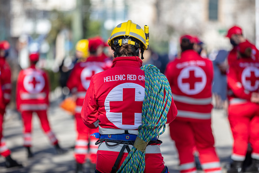 Greece Athens, March 25 2022. Volunteer of Hellenic Red Cross with full dependence at parade. Nonprofit Organization of Emergency Medic Assistance. Blur background.