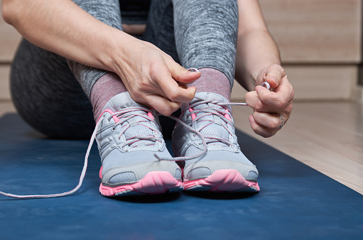Sports woman tying her shoelaces.