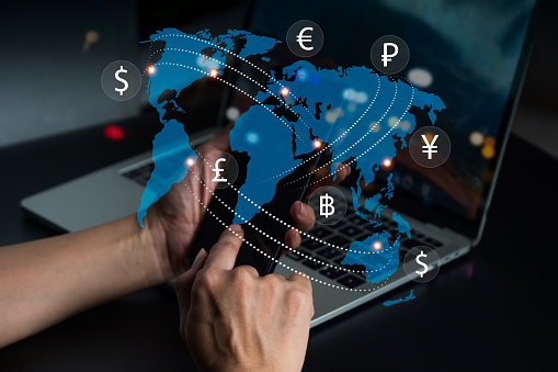 A lady with mobile phone  loaded with foreign currency. Currency exchange, money transfer, FinTech financial technology, global business, internet banking, and the notion of interbank payment.