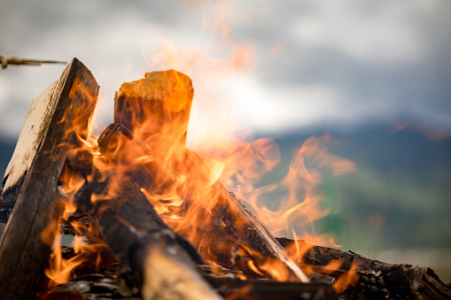 A midday campfire with a soft focus mountain range in the background