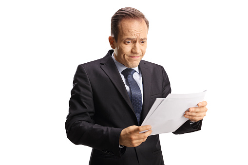 Shocked businessman looking at a document isolated on white background