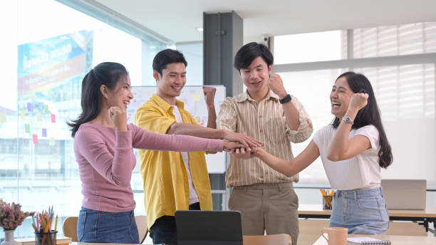 istock Startup business team stacking hands over table, showing group unity, celebrating successful teamwork or achievement. 1394131568