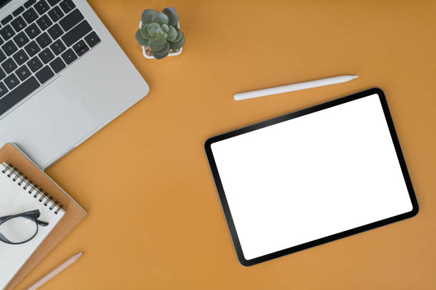 istock Mockup digital tablet, laptop and notebooks on yellow background. Blank screen for graphic display montage. 1394132888