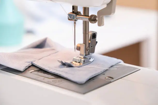 A man sews clothes on a sewing machine. Hobbies, needlework, creativity.