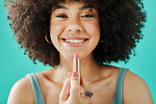 Afro model holding lipstick in the studio