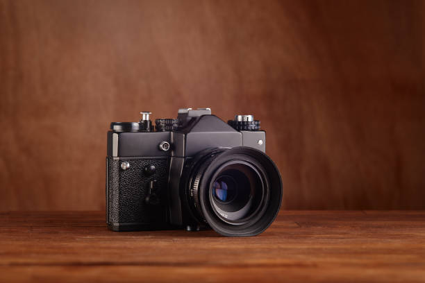 istock SLR Single-lens reflex professional camera on wooden table and background 1394146088
