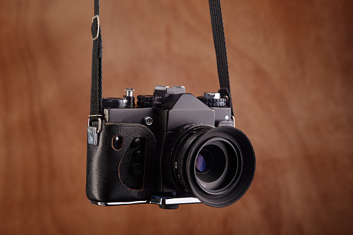SLR Single-lens reflex professional film camera hanging on its strap