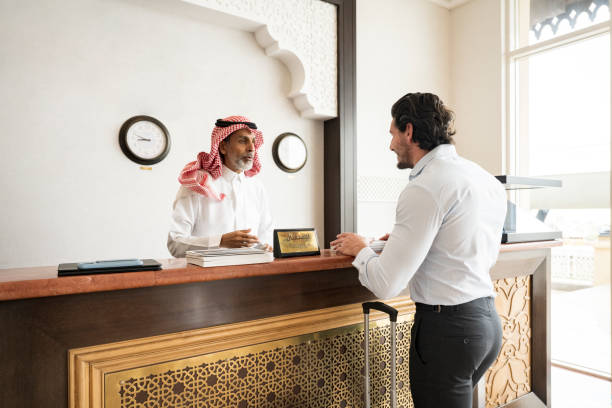 Business traveller talking with receptionist in Saudi hotel