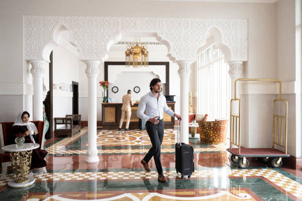 empresário saudita dos anos 30 andando pelo saguão do hotel - people traveling travel leaving disembarking - fotografias e filmes do acervo