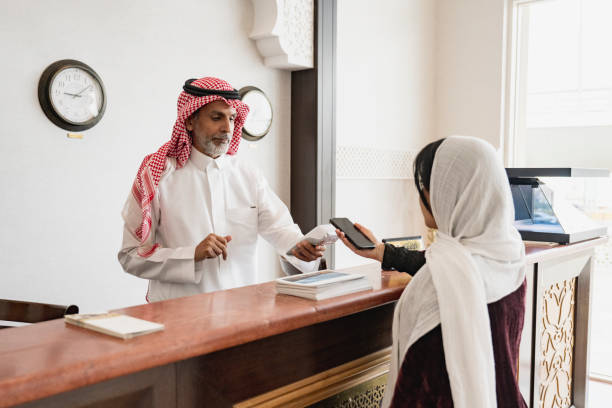 istock Saudi receptionist managing contactless payment at check-out 1394149726