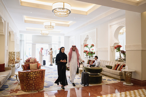 Los huéspedes del hotel saudí se mueven a través de la sala de té con equipaje photo