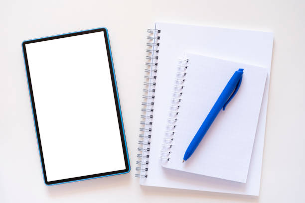 istock Planner, notebook and blue pen lie near teblet on light beige background 1394149775