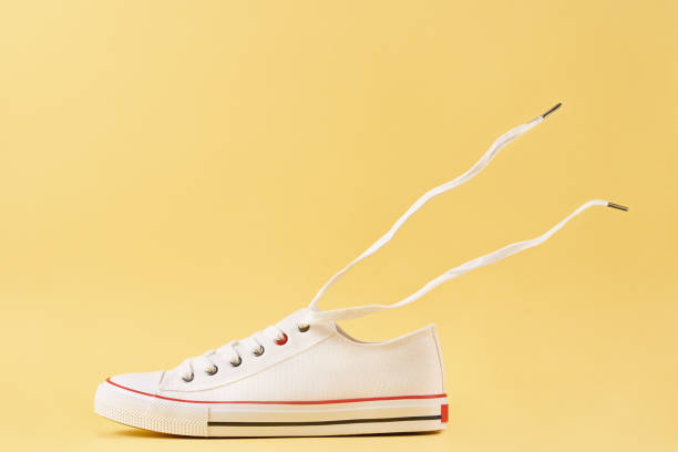 istock White casual sneakers on yellow background, creative minimalism 1394150024