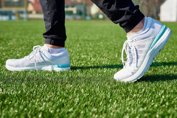 istock Runner feet running at stadium with green grass 1394151256