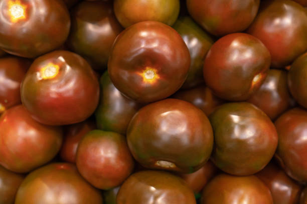 Vegetables background with black ripe tomatoes variety kumato.