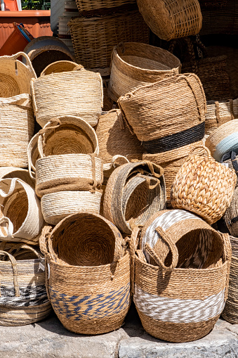 Handmade wicker round and various shaped baskets with different textures displayed for sale. Traditional handcrafted manufacture. Grand Bazaar. Assorted variety of home storage organizers, Straw lampshade and female handbags.