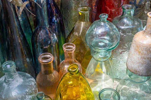 Vintage colored empty glass bottles and vases. Still life of retro style containers.  Beautiful horizontal arrangement. Ne and old recyclable garbage. Oriental, Turkish, Modern Pots and Flower Vases of Various Sizes.