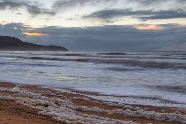 istock Sunrise seascape with sea foam and rain clouds 1394155387