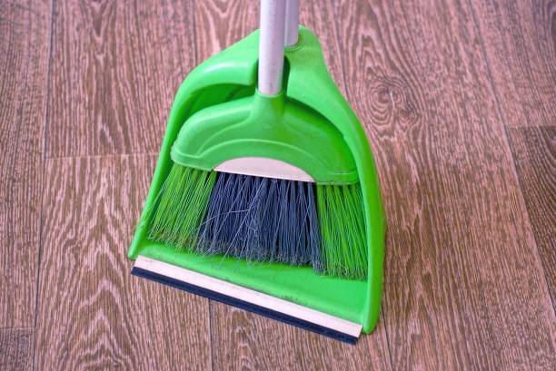 istock a green dustpan and a plastic broom stand on brown linoleum 1394157032