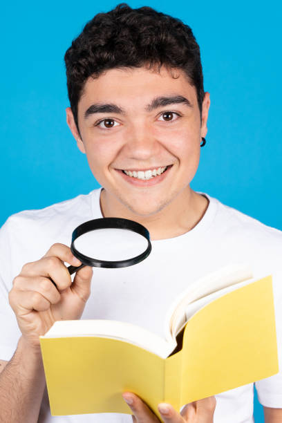 istock Hispanic man holding a book and loupe 1394157431