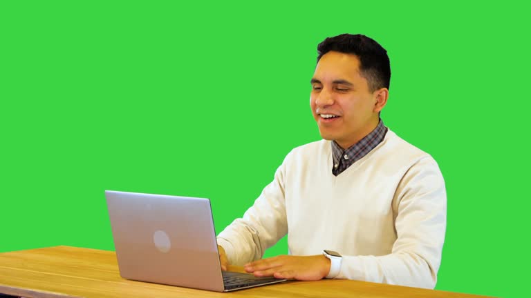 Happy hispanic guy talk with friends or family in video call conference on using laptop computer on a Green Screen, Chroma Key