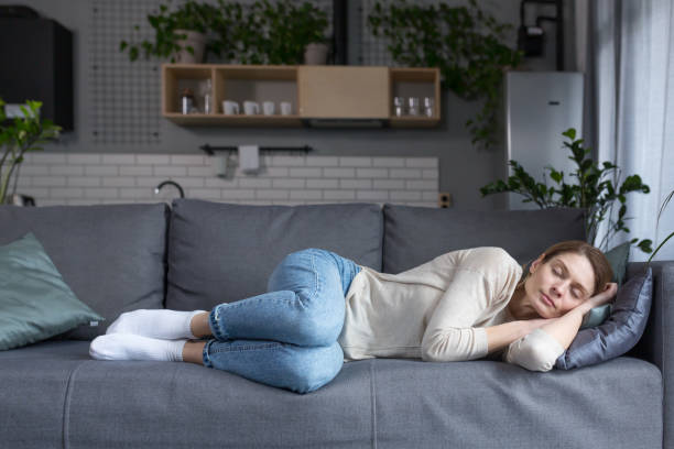 istock Tired middle aged blonde woman sleeping on sofa after work 1394158838