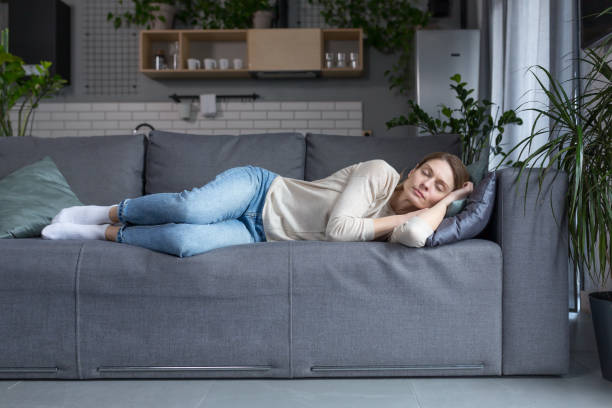 istock Tired middle aged blonde woman sleeping on sofa after work 1394158842