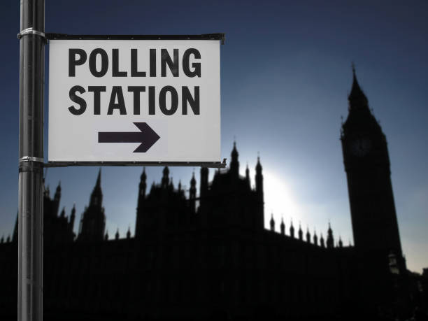 istock polling station sign over blurred parliament background 1394161632
