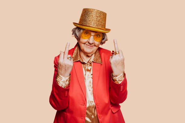 istock Funny elderly grandmother showing middle finger at studio 1394161861