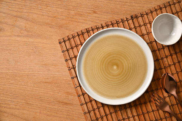 istock Mockup of empty ceramic plate, bowl and silverware on bamboo place mat 1394163860
