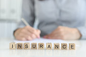 istock Insurance agent fills out insurance form in office closeup 1394163968