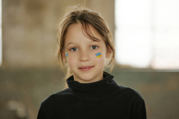 Ukrainian girl with a national flag painted on her face stock photo