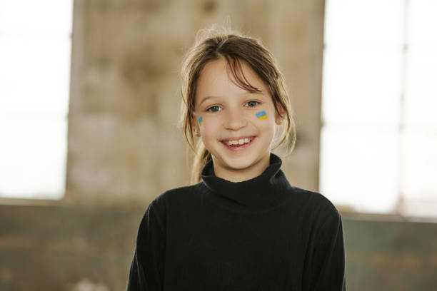 Ukrainian girl with a national flag painted on her face stock photo