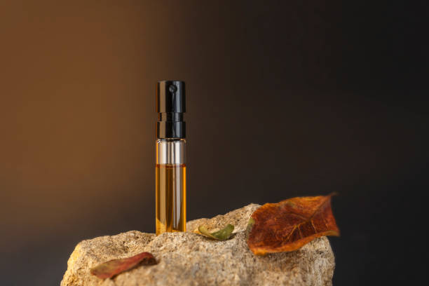 muestra de perfume de pie sobre una piedra con hojas de manzana. concepto de perfumería de otoño - musk fotografías e imágenes de stock