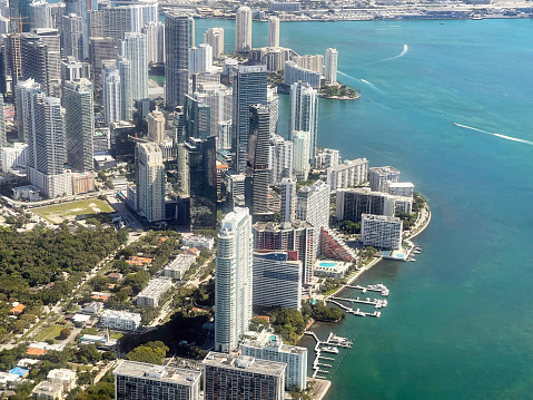 Aerial view from midair of downtown Miami from over the Florida coastline, looking at the high rise skyscrapers of Miami City, Miami-Dade County, Florida, USA