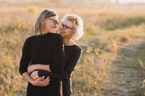 pareja de lesbianas caucásicas del mismo sexo al aire libre en el fondo de la hermosa naturaleza. - multi ethnic group couple sex women fotografías e imágenes de stock