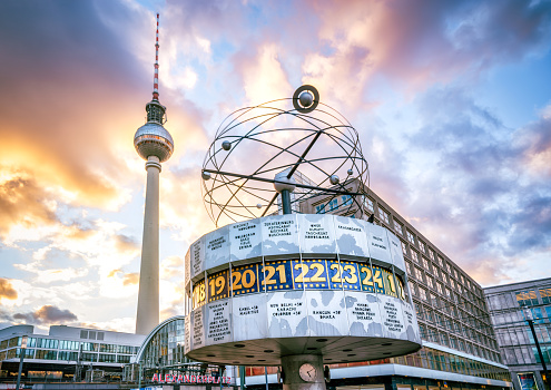 Berlin, Germany - February 26, 2022: Alexanderplatz in Berlin at sunset. On the right the Weltzeituhr ( World Clock ) is an astronomical clock installation located in Alexanderplatz, Berlin - behind the television tower.