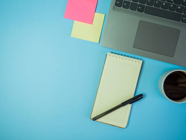 istock Business office desk concept ideas. top view with laptop, coffee and blank notepad on blue background.copy space 1394171536