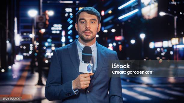 Anchorman Reporting Live News In A City At Night News Coverage By Professional Handsome Reporter From A Business District Journalist Presenting News For Tv Channel Newscaster Talking Stock Photo - Download Image Now