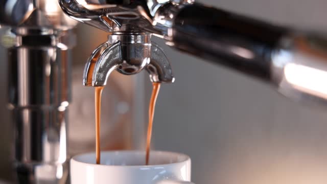 Espresso dripping out of a professional machine