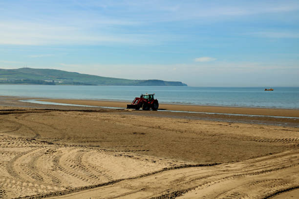 Tractor working on a coastal beach levelling sand